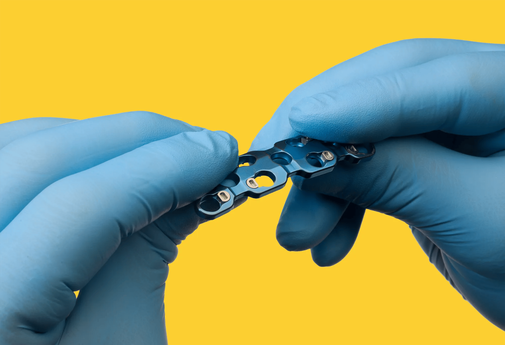 Technician handling precision implantable medical device component in clean environment